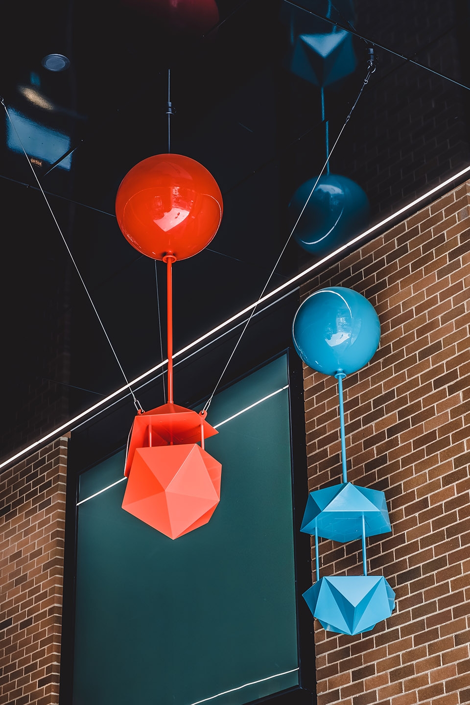 delicate and playful sculptures hang mid air in pedestrian walkway by uap