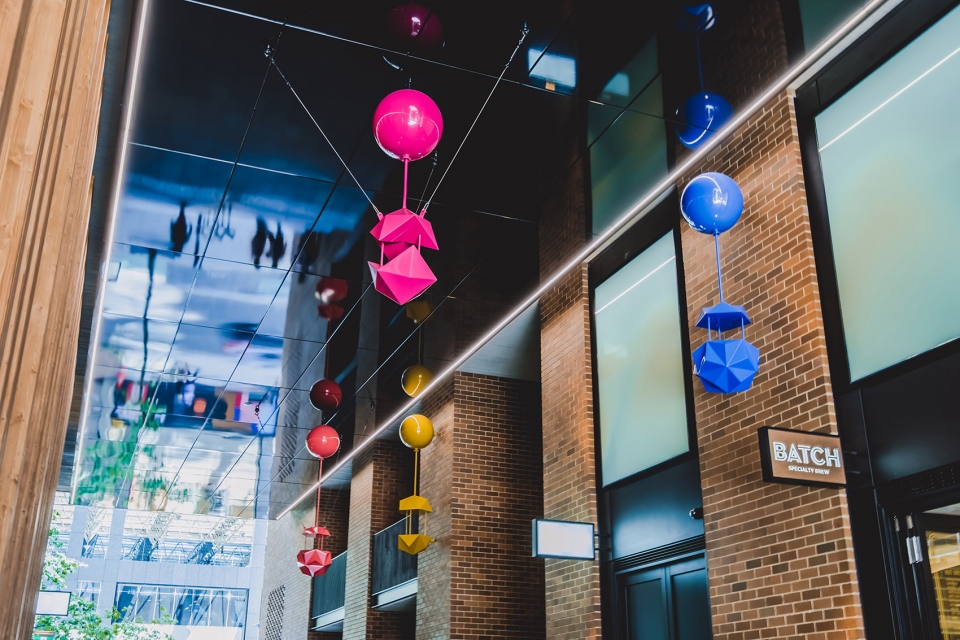 delicate and playful sculptures hang mid air in pedestrian walkway by uap