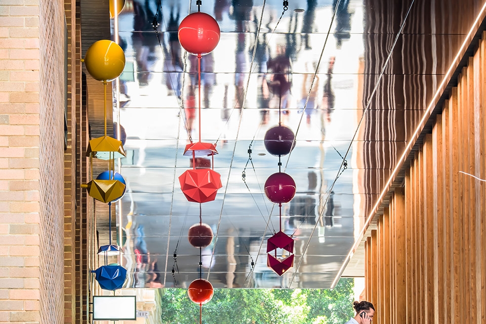 delicate and playful sculptures hang mid air in pedestrian walkway by uap
