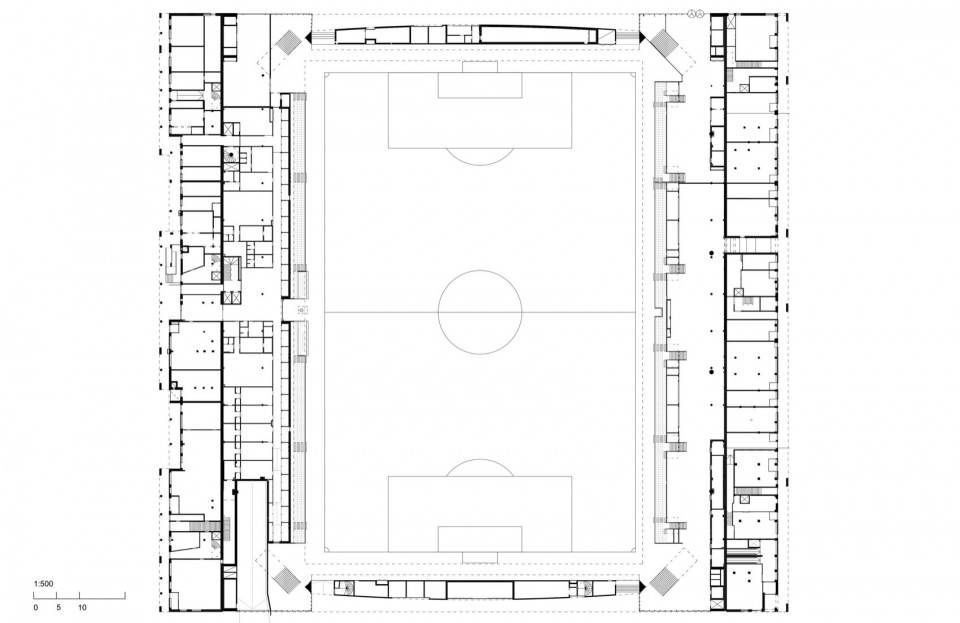 Ground floor with commercial spaces east and west and the football pitch in the middle. © JKMM Architects