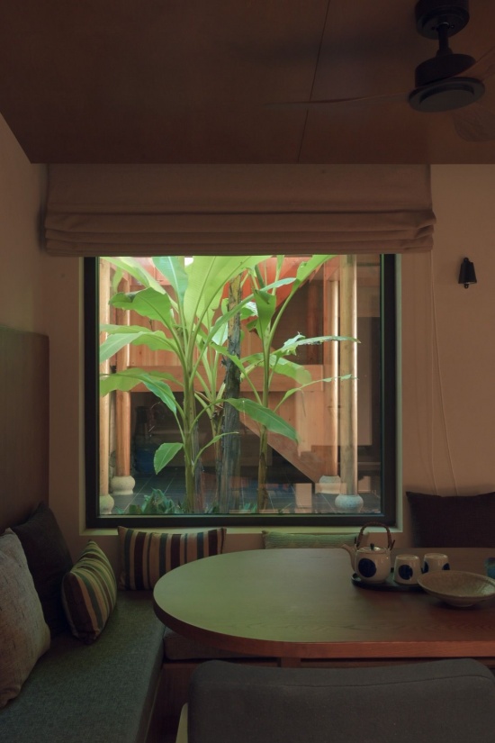 有天井的客房的小客厅看天井里的芭蕉被光照亮 / A guest-room sitting area looking onto sunlit banana leaves in the courtyard