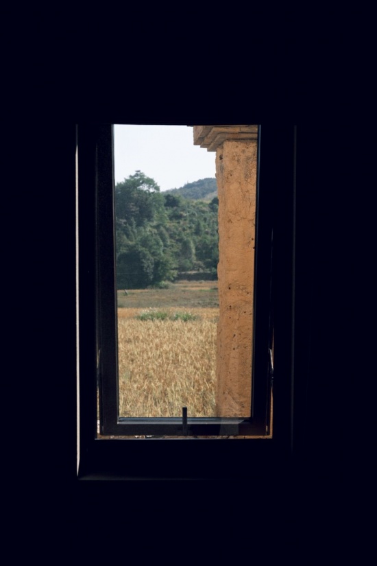 面对梯田的客房玄关窗景,还可以看到一点老的夯土屏风墙 / A guest-room entrance window facing the terraces, with a glimpse of the old earthen screen wall