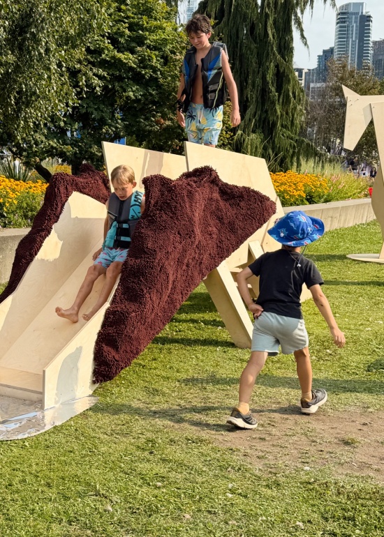 刚跳完水的孩子们顺着滑梯马滑向反光的“水面” / children fresh from the water sliding down towards the reflective “water surface”