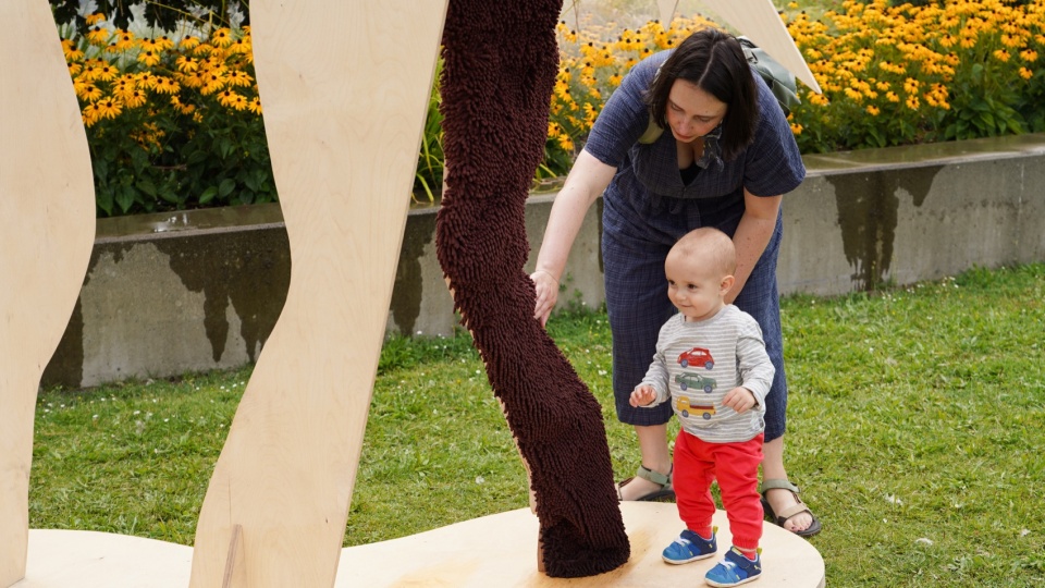游客触摸柔软的雪尼尔马腿 / a visitor touching the soft chenille horse leg
