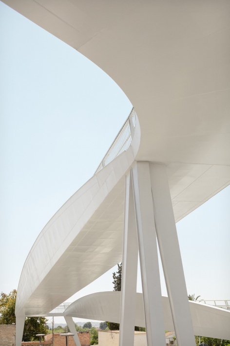 从桥下仰望桥身弧线 / Looking up at the curve of the bridge from below
