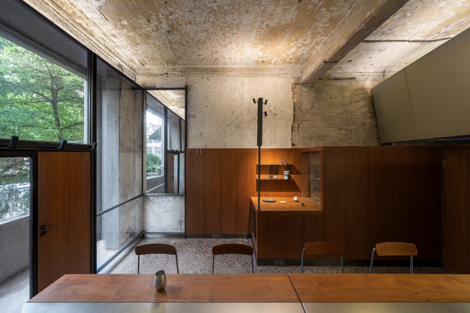 从长桌区望向入口与通高玻璃钢窗 / view from the table area towards the entrance and the full-height glass window
