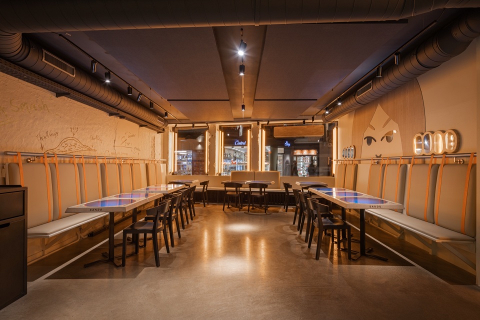 暖光中的长排卡座 / Bench seating in warm light