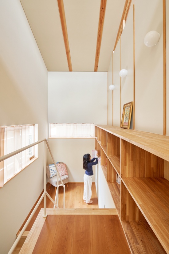 挑空旁的内置书架与坐席 / Built-in shelving and seating beside the void