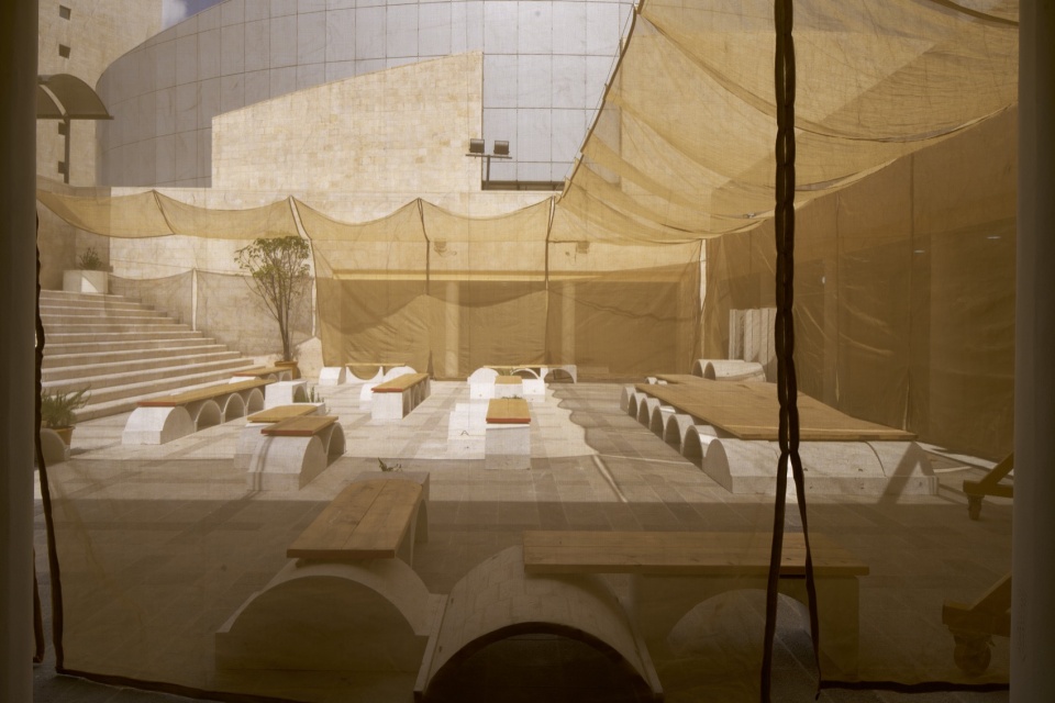 织物下的石拱座席 / Stone vault seating beneath the fabric canopy